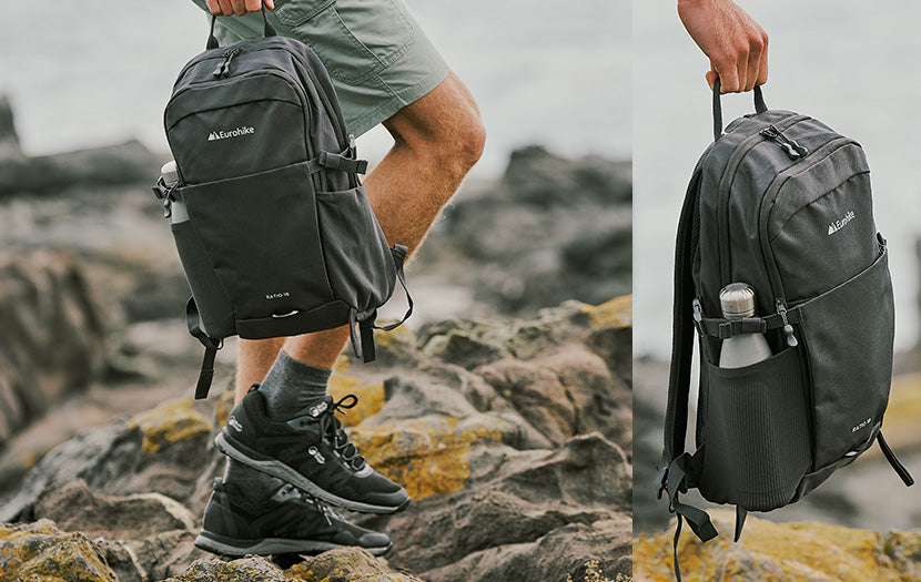 A person outdoors on rocky shoreline holding a dark gray Columbia backpack in both a full-body side view and a close-up side panel. The backpack has visible Columbia branding and a side water bottle pocket with a clear bottle inserted.