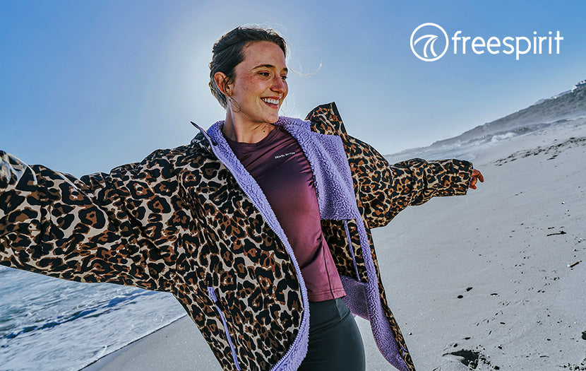 Person wearing a leopard-print fleece-lined jacket on a beach, with Freespirit branding in the top-right corner.